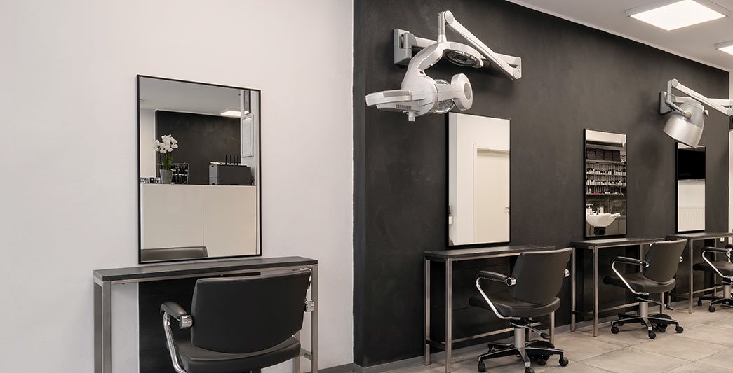 Blick in den Salon von Thomas Herrmann in Kassel: schwarze Wand, Spiegelplätze und Bedienungsstühle